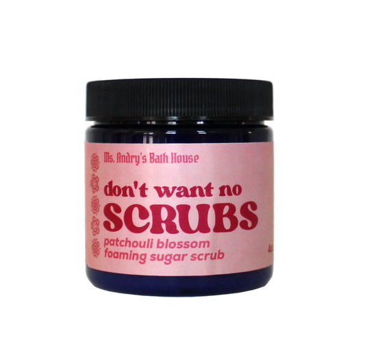 Jar of 'don't want no scrubs' patchouli blossom foaming sugar scrub with pink label on a white background