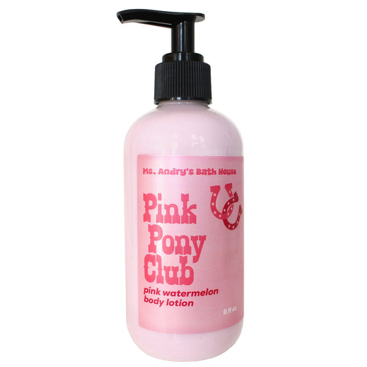 Pink bottle of 'Pink Pony Club' body lotion with a black pump on a white background